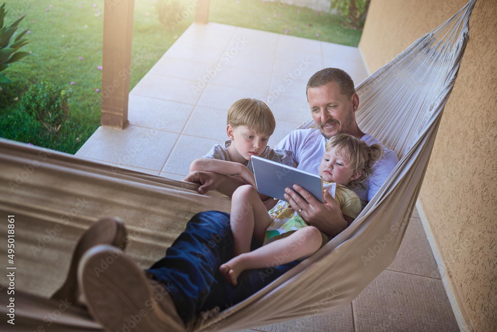 Swinging along to a chilled weekend with the kids. Shot of a father and his two little children usin