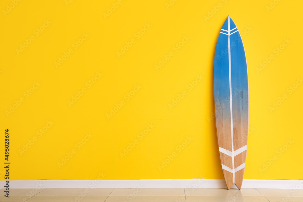 黄色墙壁附近的蓝色冲浪板