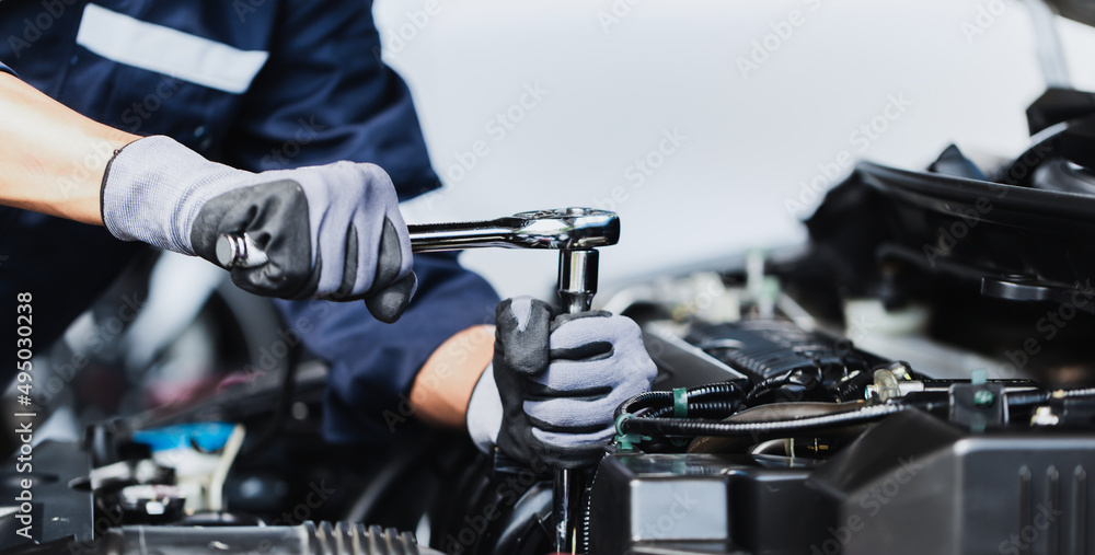 在车库里修理汽车发动机的专业机械师。汽车维修服务。
