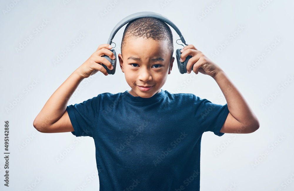 当我长大后，我想成为一名DJ。一个可爱的小男孩戴着耳机对着灰色b的演播室镜头
