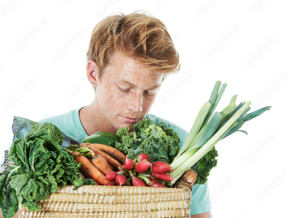 没有什么比新鲜农产品更好的了。一个英俊的红头发年轻人闻着一篮新鲜蔬菜