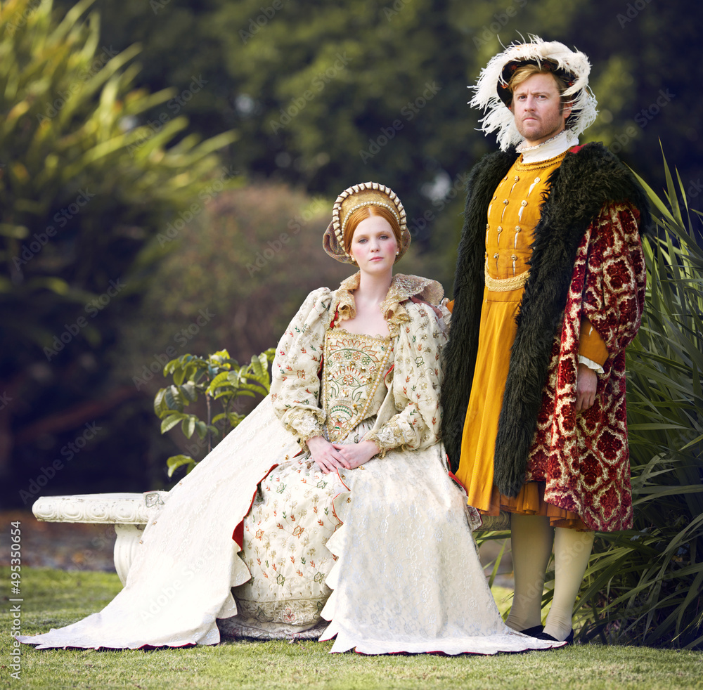 她的国王在她身边。一对皇室夫妇在花园里共度时光的照片。