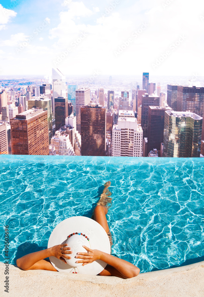 一位女士在屋顶游泳池放松，欣赏纽约美景