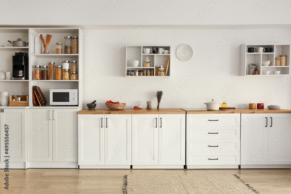 带白色柜台、架子和食物的轻型现代厨房内部