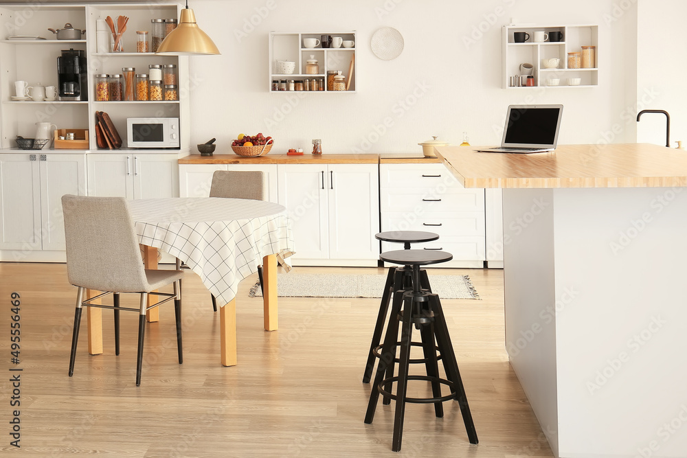 带白色柜台、架子和餐桌的轻型现代厨房内部