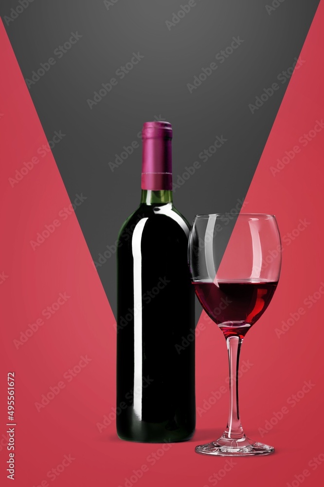 多色背景的红酒瓶和玻璃杯