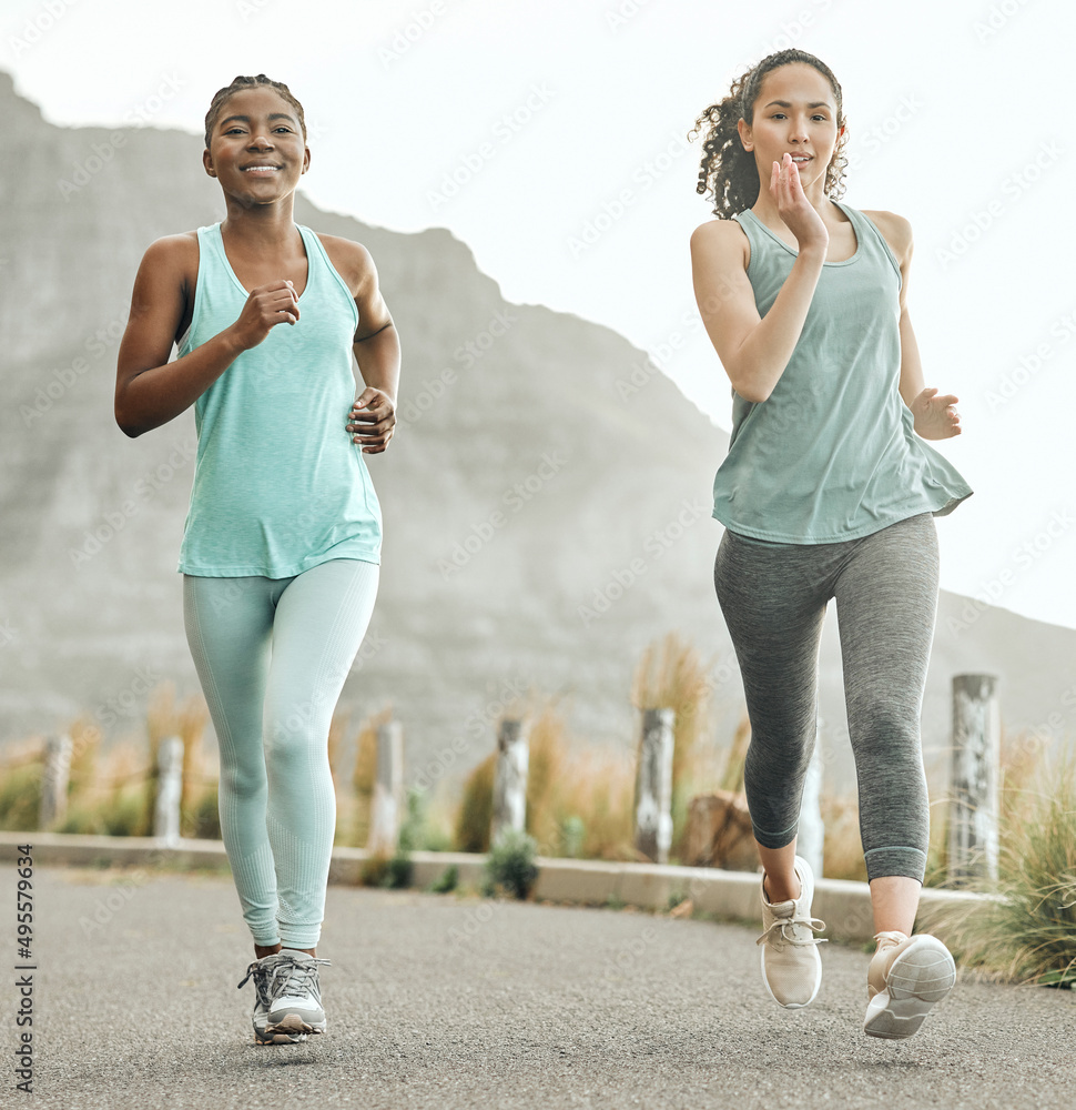 一起努力实现我们的健身目标。两名年轻女子早上跑步的照片。