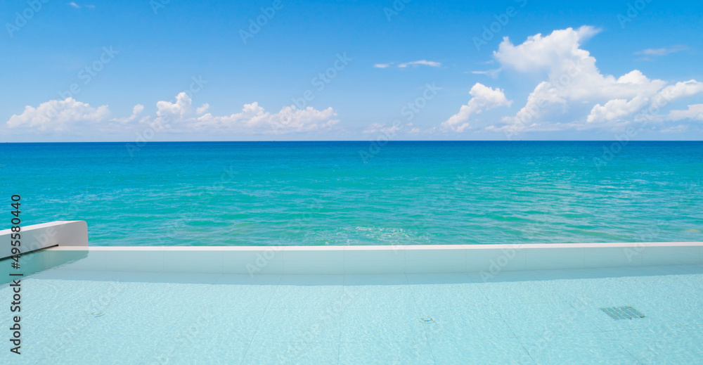 游泳池俯瞰热带海洋和晴朗的蓝天背景。暑假和旅行