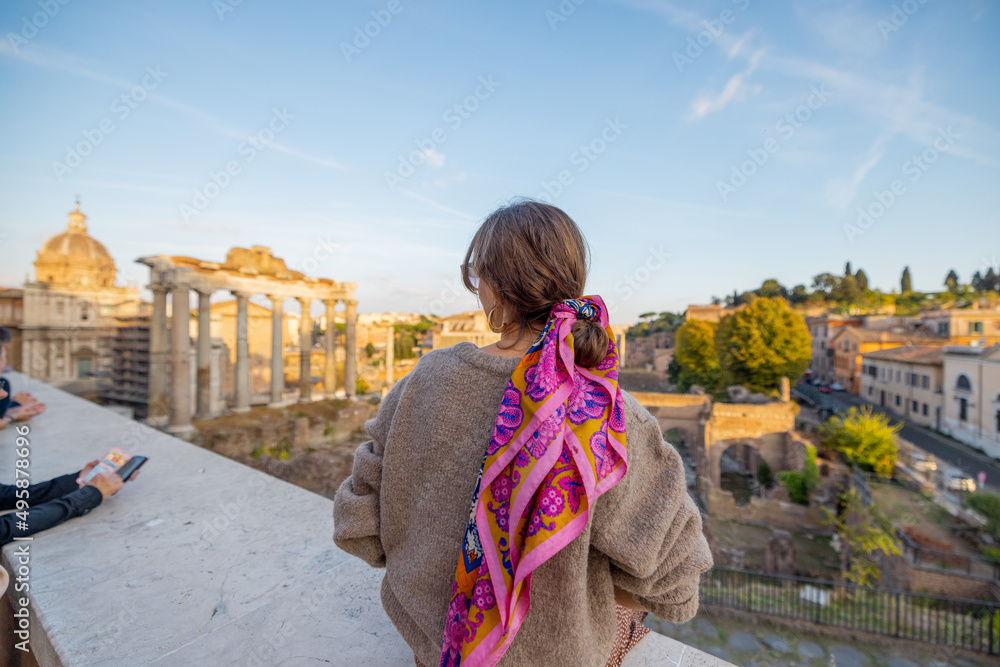 女人在罗马论坛上欣赏风景，日落时罗马市中心的废墟。旅行的概念