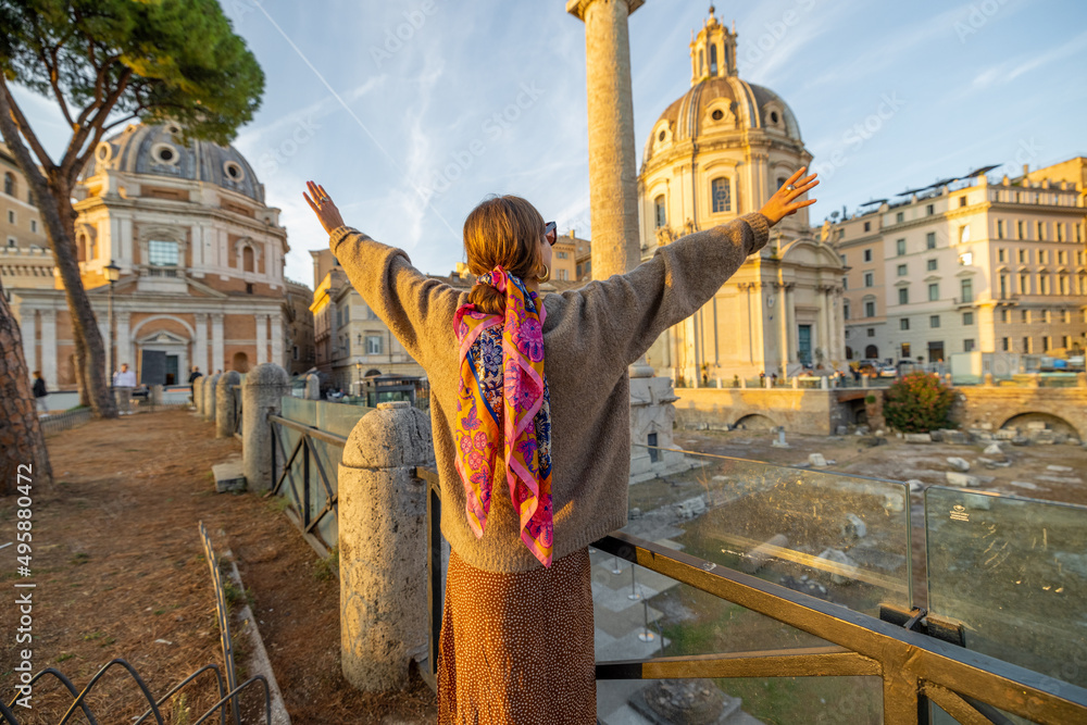 女人在罗马论坛上欣赏美丽的日落。意大利之旅和名人之旅的概念