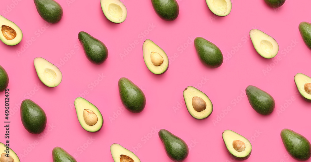 Many ripe avocados on pink background