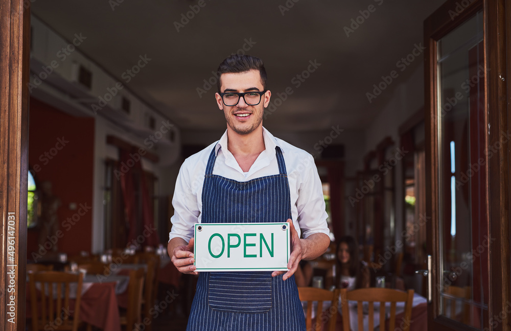 进来吧，吃得好，感觉好极了。一名男子在餐厅挂开放式招牌的镜头。