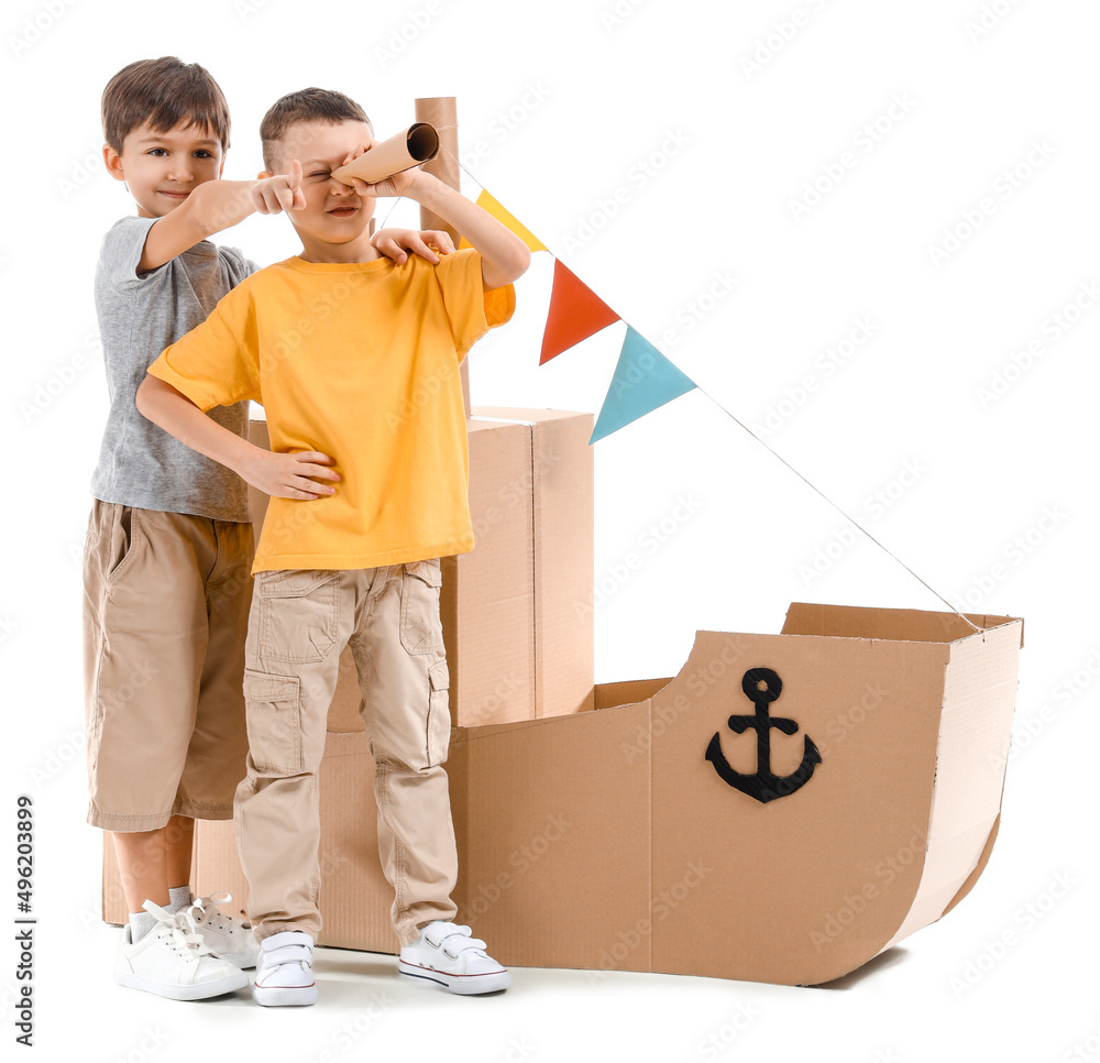 有趣的小男孩在白色背景下玩纸板船