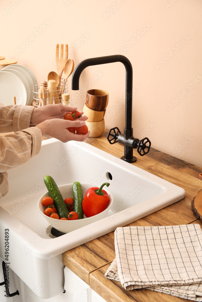 女人在厨房水槽上洗樱桃番茄