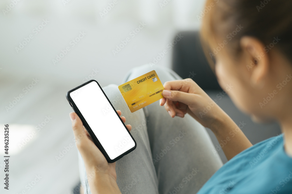 在线支付。女人拿着空白屏幕的智能手机和信用卡，进行金融交易