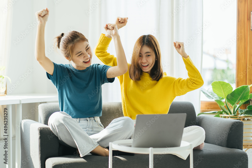 年轻的亚洲女性，兴奋的女性为庆祝网上胜利而欢欣鼓舞