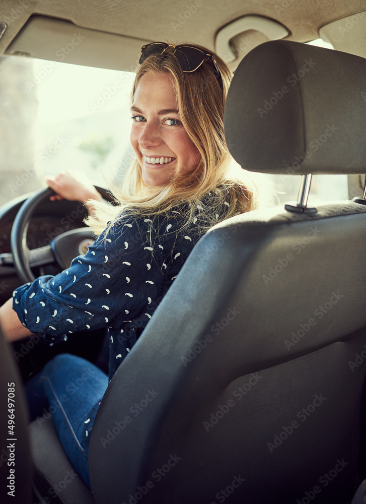 让我们上路吧。一个漂亮的年轻女人开车的画像。