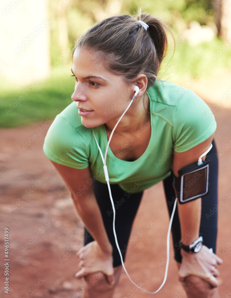 期待一场精彩的跑步。一张年轻女子在跑步时听音乐的照片。