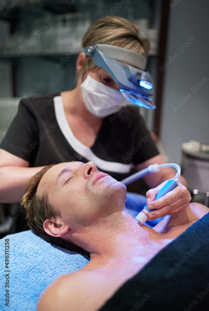 现代技术让美容不再痛苦。一名男子在美容师处进行非侵入性面部提升的照片