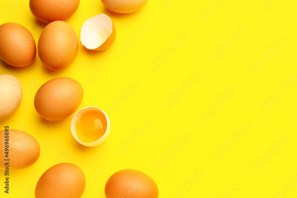 Cracked and whole chicken eggs on yellow background