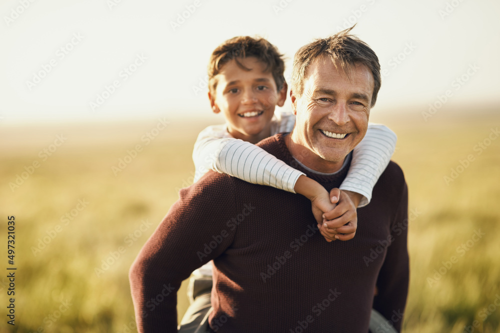 开始花更多的时间在户外陪孩子。一个成熟男人背着儿子的照片。
