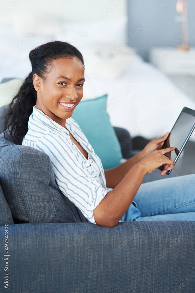 幸福是全天的连接。一位年轻女性在家使用数字平板电脑的肖像。