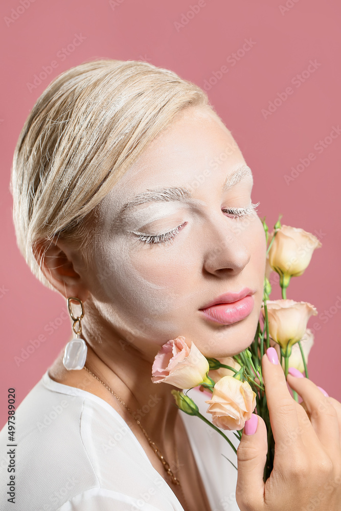 Beautiful young woman with creative makeup and eustoma flowers on color background