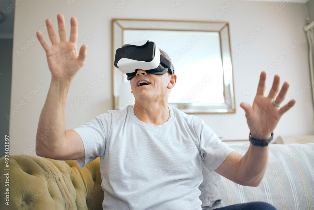走进另一个世界。一个成熟男人在家里使用VR耳机的镜头。