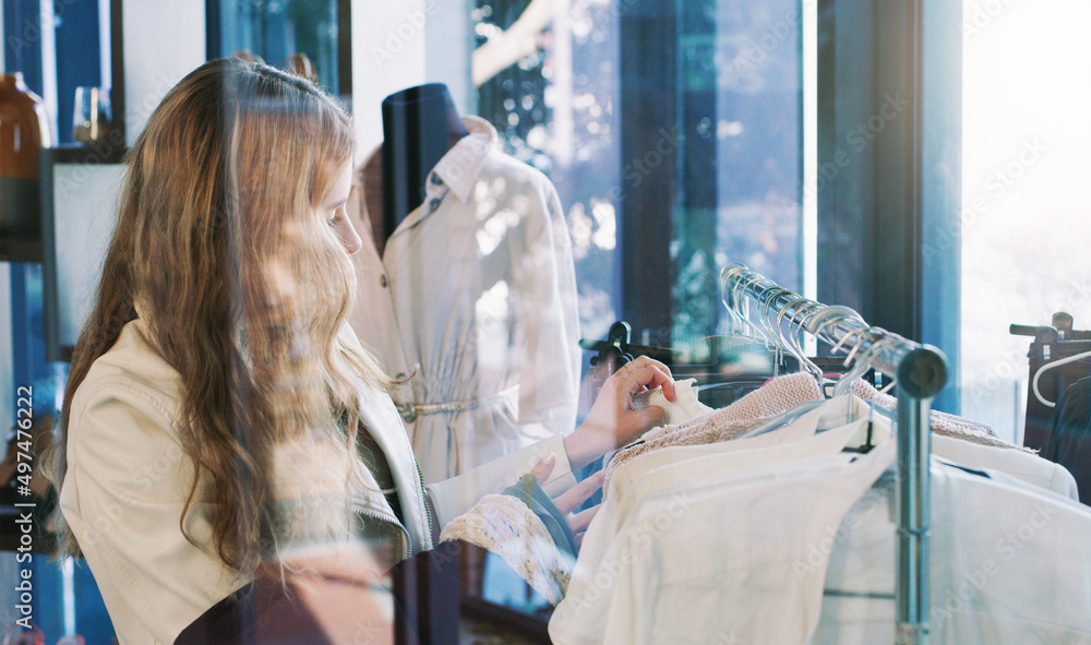 购物到掉线。一张年轻女子在精品店浏览衣服的照片。