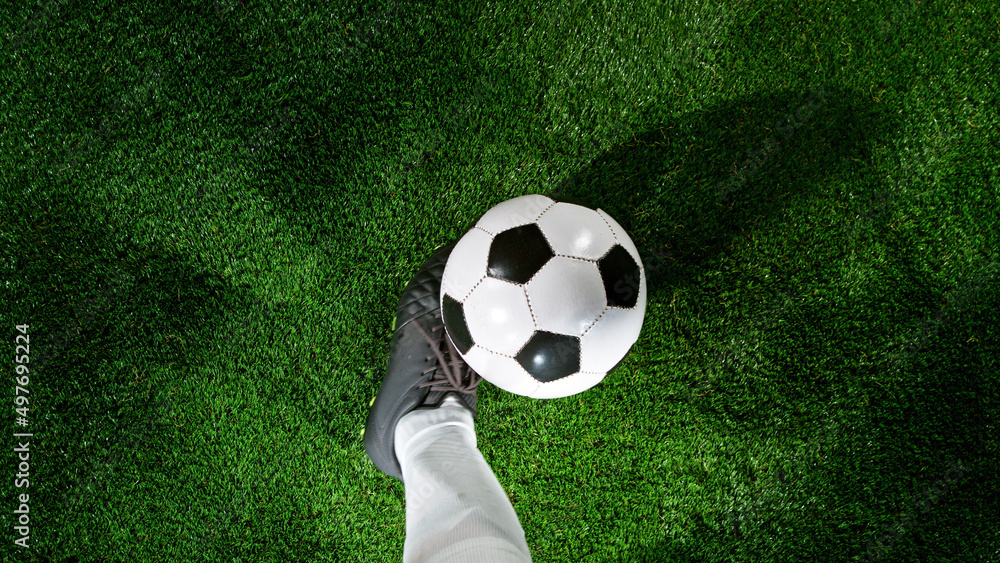 在草地上踢球的足球运动员，顶杆。