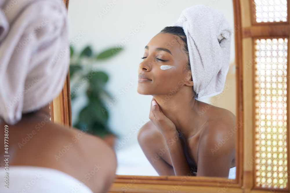 完美的皮肤感觉很好。一位迷人的年轻女子在镜子里检查自己的脸的裁剪镜头