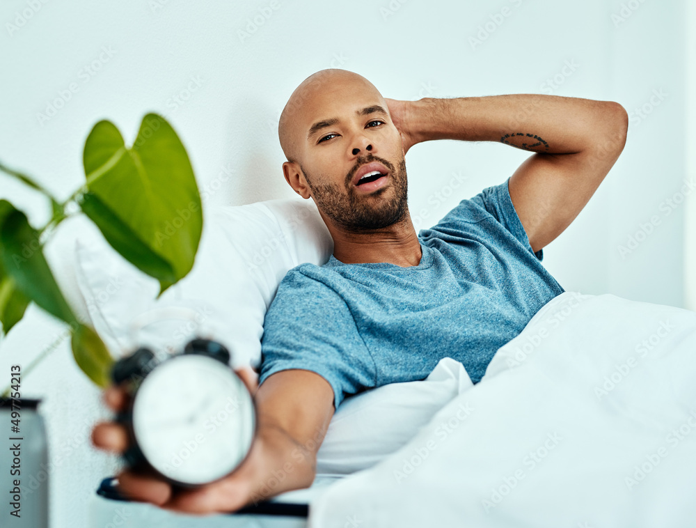 已经到那个时候了吗？一个男人躺在床上举起闹钟的镜头。