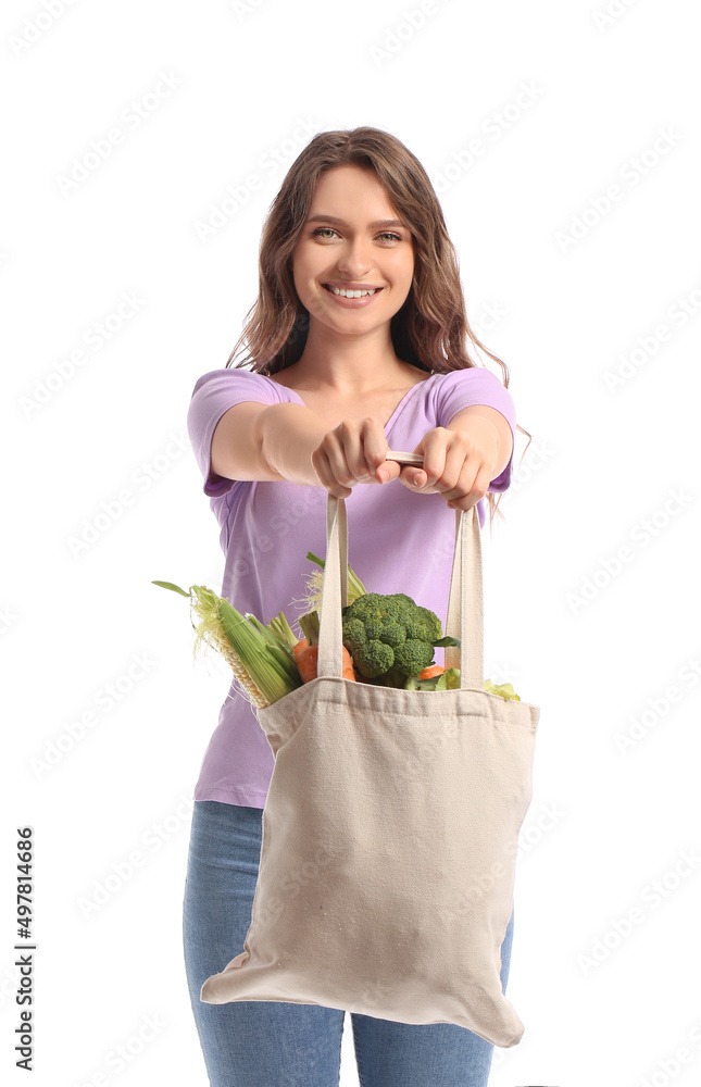 年轻女子拿着环保袋，白色背景是健康的蔬菜