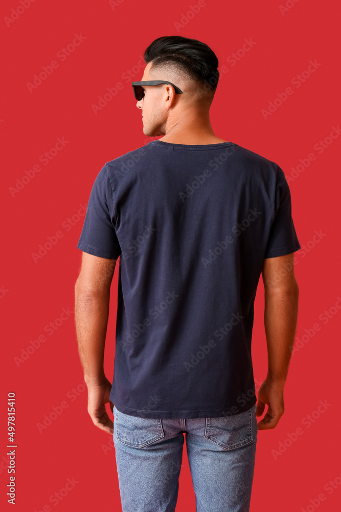 英俊的年轻人穿着时尚的t恤，彩色背景，背面视图