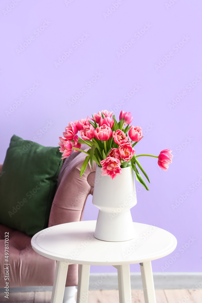 房间扶手椅附近桌子上的郁金香花瓶