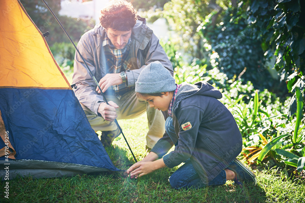 周末与父亲在野外。一位父亲和他的小儿子搭建帐篷的镜头。