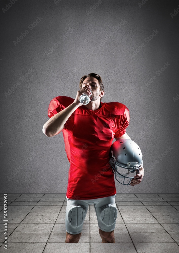 白人男性橄榄球运动员在灰色背景下对着复制空间喝水