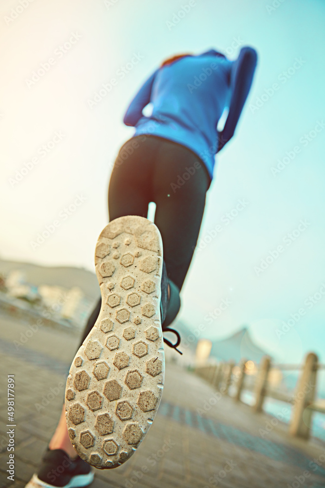 在跑步方面，合适的鞋子很重要。一个运动型年轻女性外出跑步的镜头
