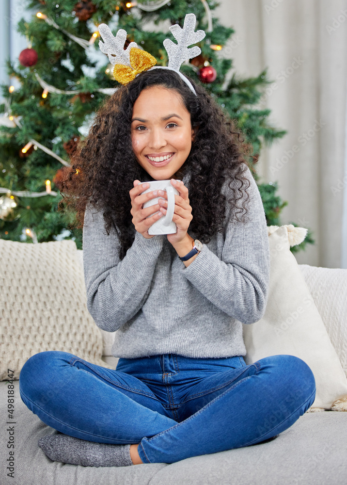 在家里保持舒适。一名年轻女子在家里的圣诞节期间喝咖啡的照片。