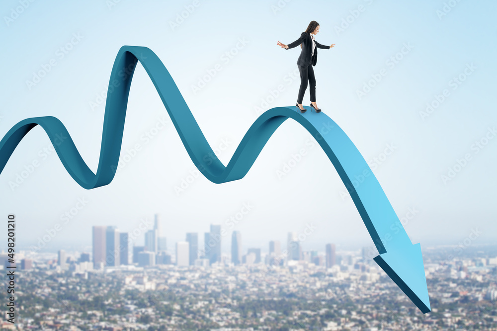 Attractive european businesswoman balancing on abstract falling blue arrow on sky and city backgroun