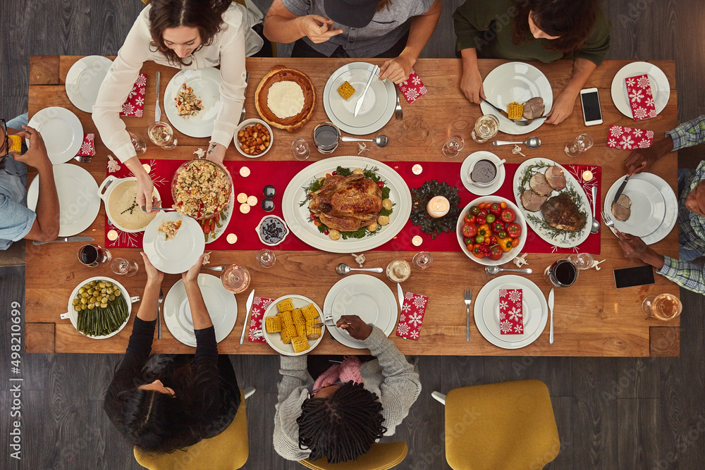 食物让聚会变得容易。一群人坐在餐桌旁准备的照片