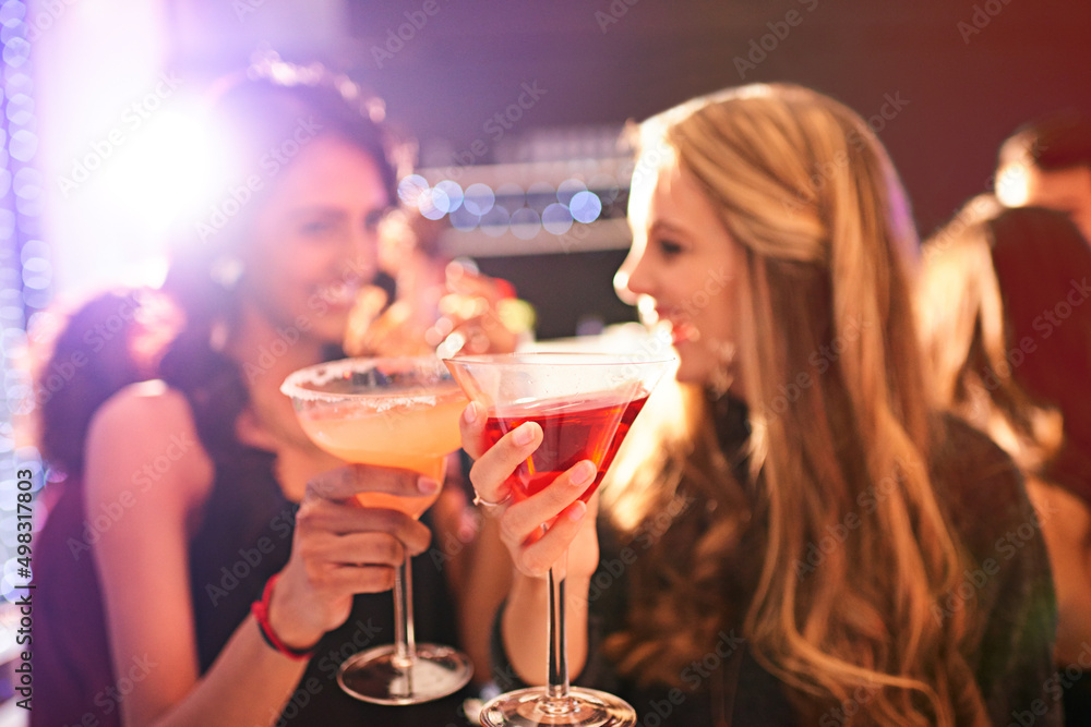 喝酒前先喝一杯。两个年轻女人在派对上喝鸡尾酒的镜头。