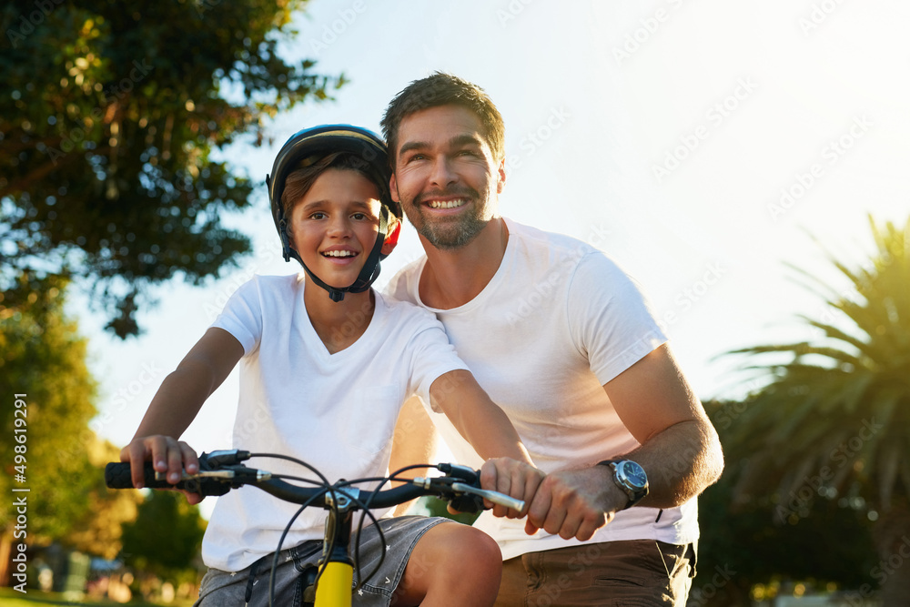 骑自行车穿过他的街区。一个小男孩骑着自行车穿过他的邻居的照片。