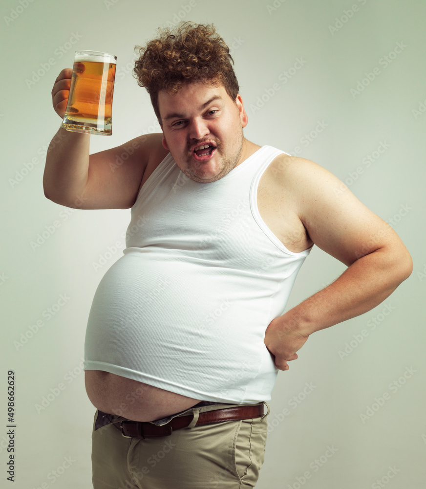 干杯。一个超重男子在吐司中举起啤酒的镜头。