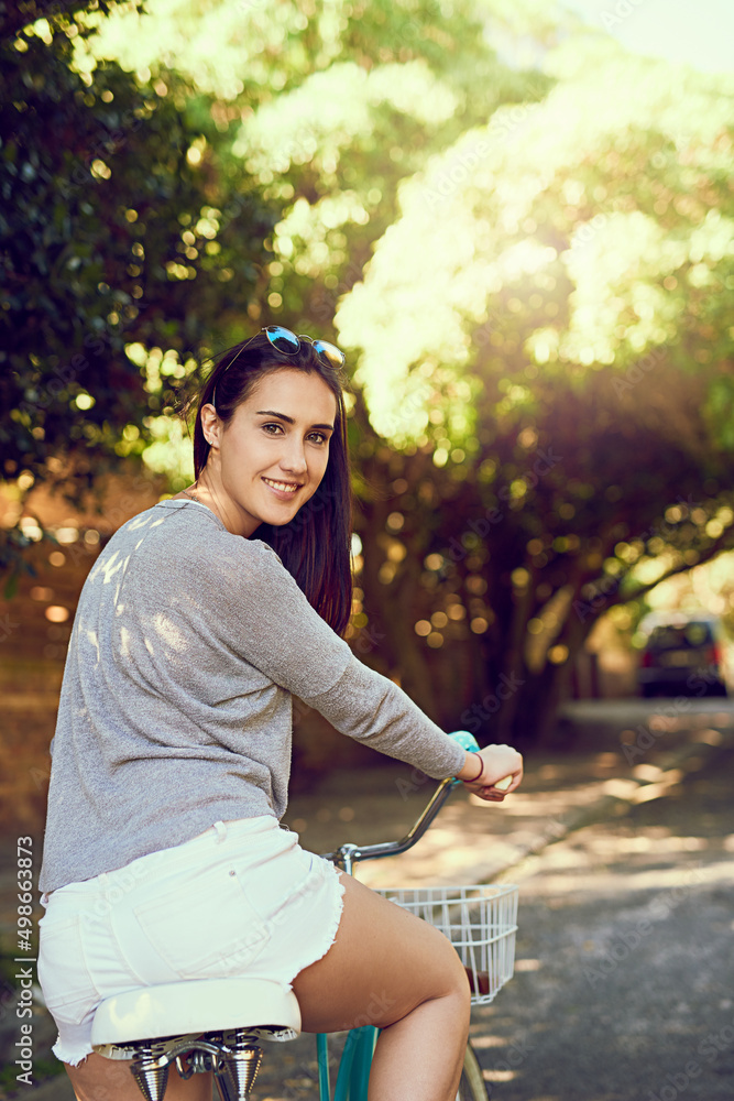 生活是一次美丽的骑行。一位迷人的年轻女子在外面骑自行车的肖像。