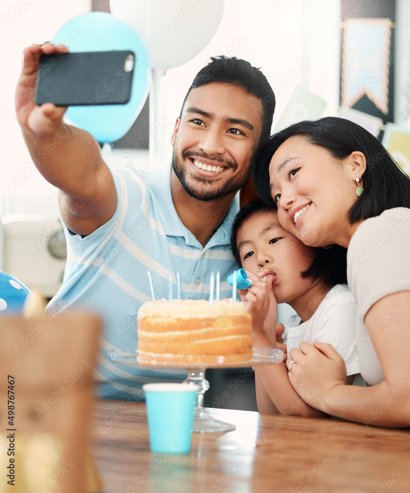 Work hard. Play hard. Eat lots of cake. Shot of a happy family taking selfies while celebrating a bi