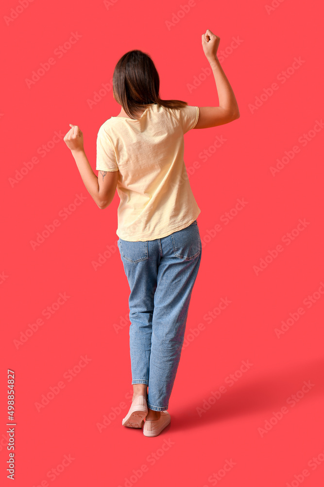 快乐的年轻女人，穿着彩色背景的空白t恤，背面视图