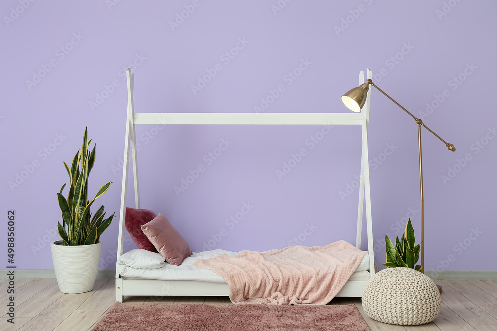 带床、标准灯和紫色墙壁的时尚房间内部
