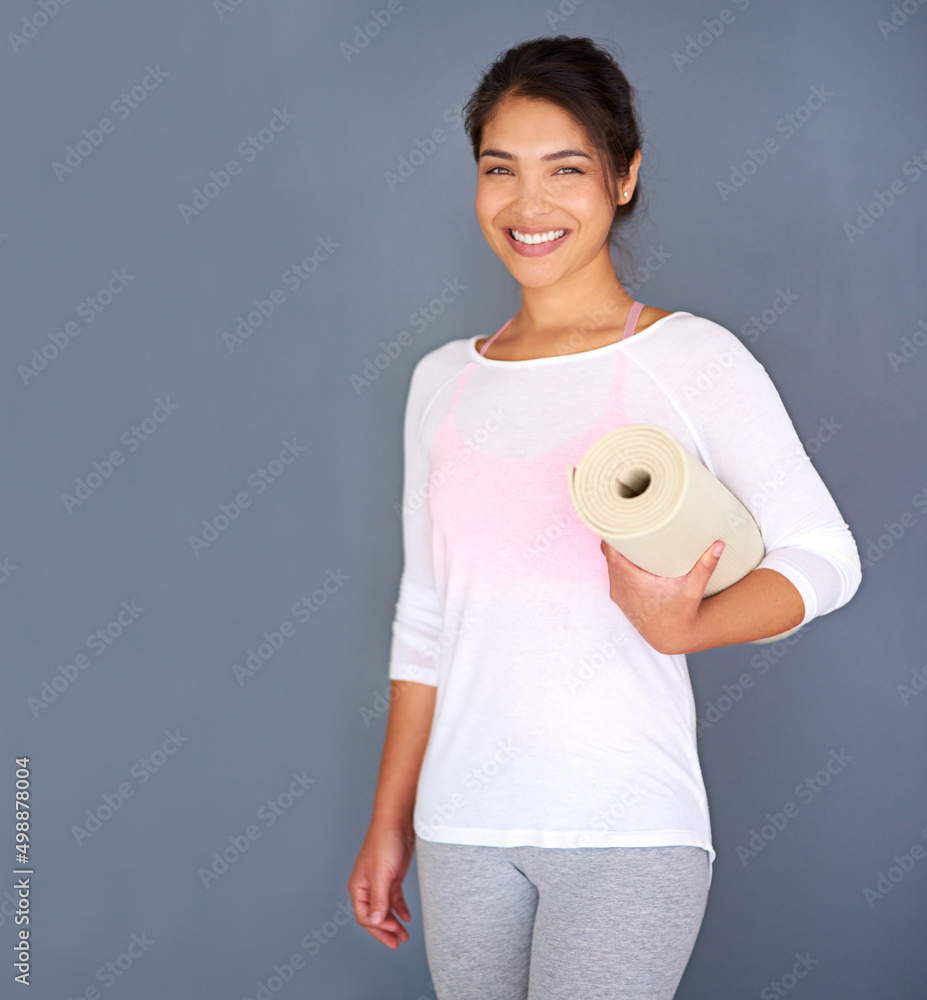 Believe you can and youre halfway there. Cropped shot of a sporty young woman holding her yoga mat a