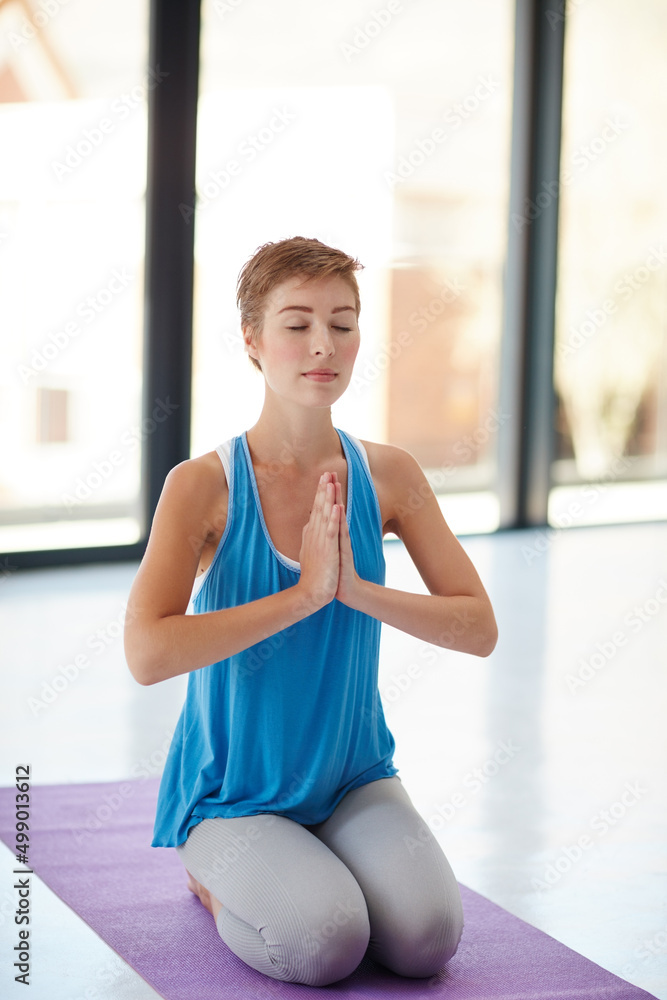 最好的陪伴是你自己的心。一张年轻女子在健身房练习瑜伽的照片。